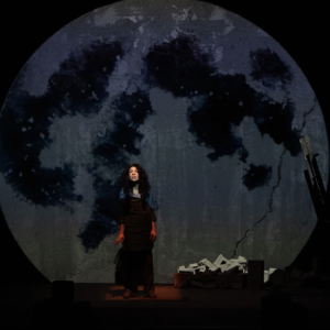 Woman In Front A Huge Projection Of A Full Moon